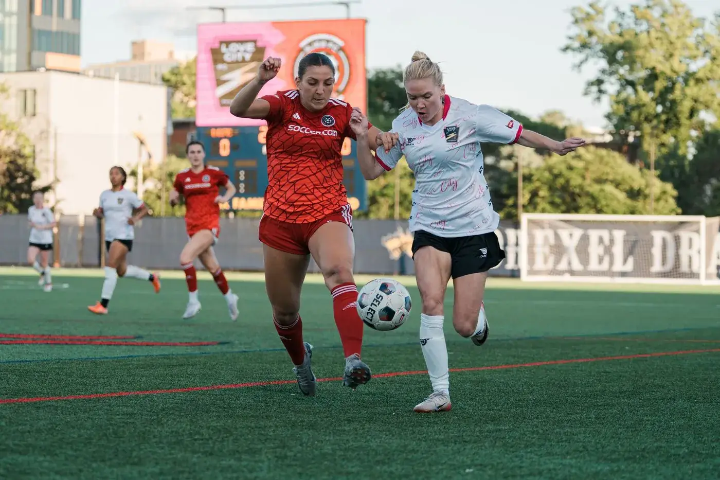 A Love City FC player shields the ball on the touchline at Vidas Field, Drexel University