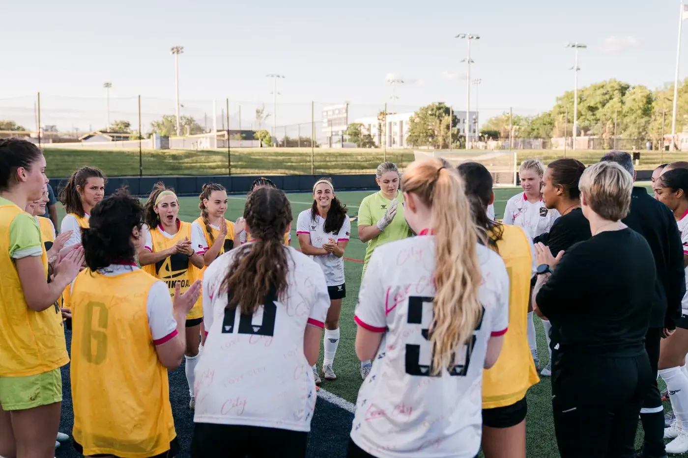 The Love City FC women's soccer squad in a huddle after a match